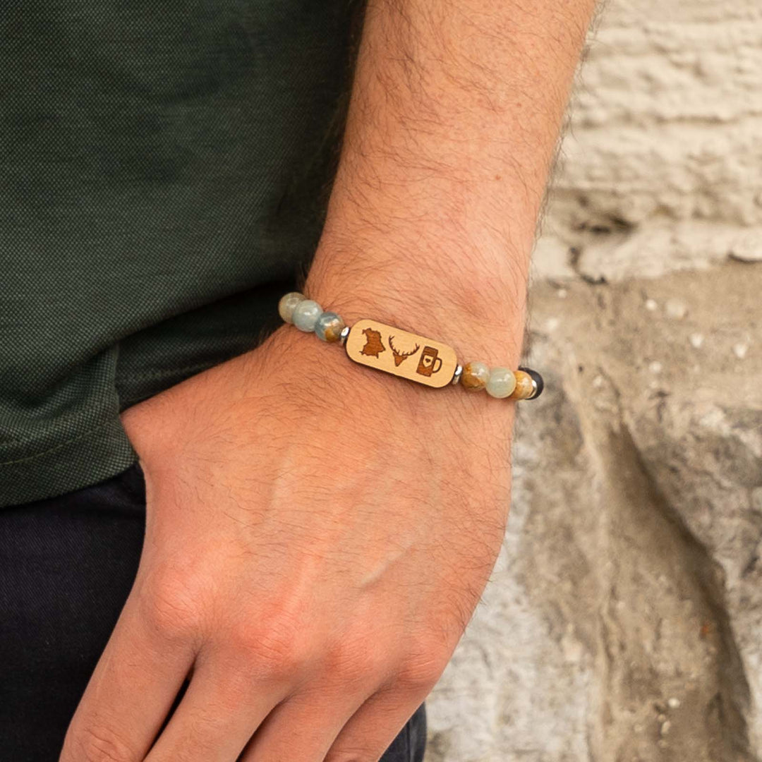 Edelsteinarmband mit bayerischen Symbolen auf Kirschholz – Umriss, Maßkrug und Hirschkopf kombiniert mit blauem Calcit und schwarzem Onyx