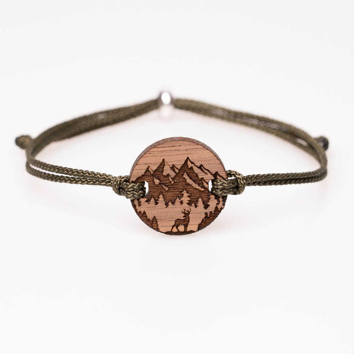 Nussbaumholz-Armband mit Gravur: Bergsilhouette und Hirsch im Vordergrund, olivgrünes Nylonband, personalisiertes Naturarmband – handgemachter Holzschmuck als Geschenk für Alpenfans