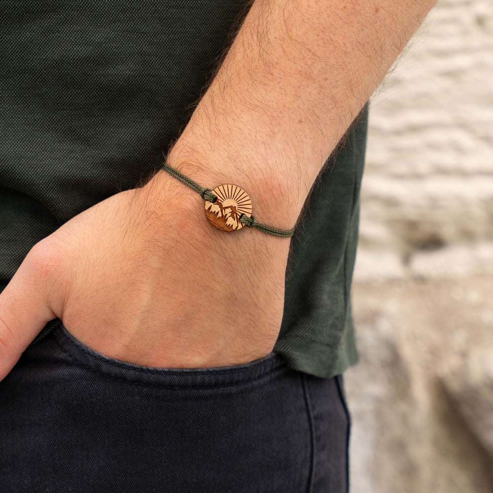 Armband mit Berglandschaft und Waldmotiv auf Kirschholz – naturverbundener Holzschmuck mit olivgrünem Band