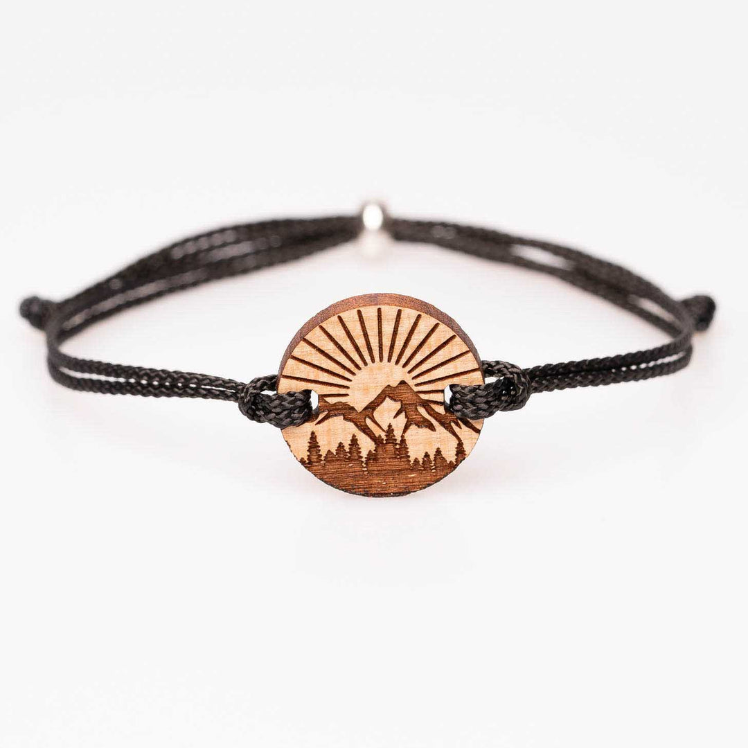 Personalisiertes rundes Kirschholz-Armband mit Gravur: Berglandschaft, Wald und Sonne, schwarzes Nylonband, handgemachter Holzschmuck als Geschenkidee für Wanderer und Naturliebhaber