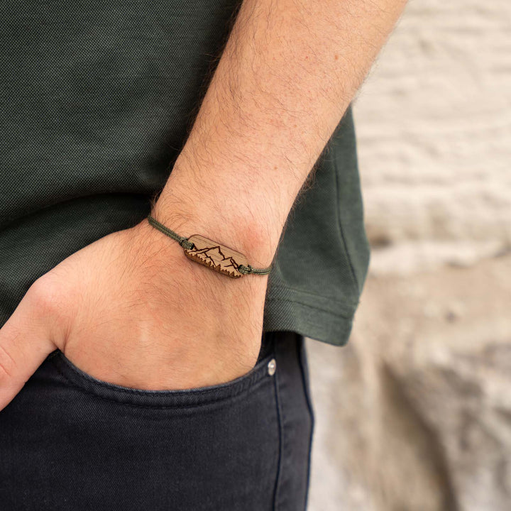 Graviertes Armband mit Bergsilhouette auf Nussbaumholz – olivgrünes Band und individuelle Gravur auf der Rückseite möglich