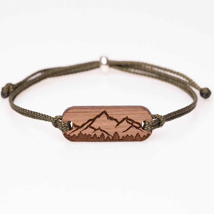 Nussbaumholz-Armband mit Gravur einer Berg Silhouette und Wald im Vordergrund, olivgrünes Nylonband, personalisiertes Naturarmband – einzigartiges Geschenk für Alpenfans