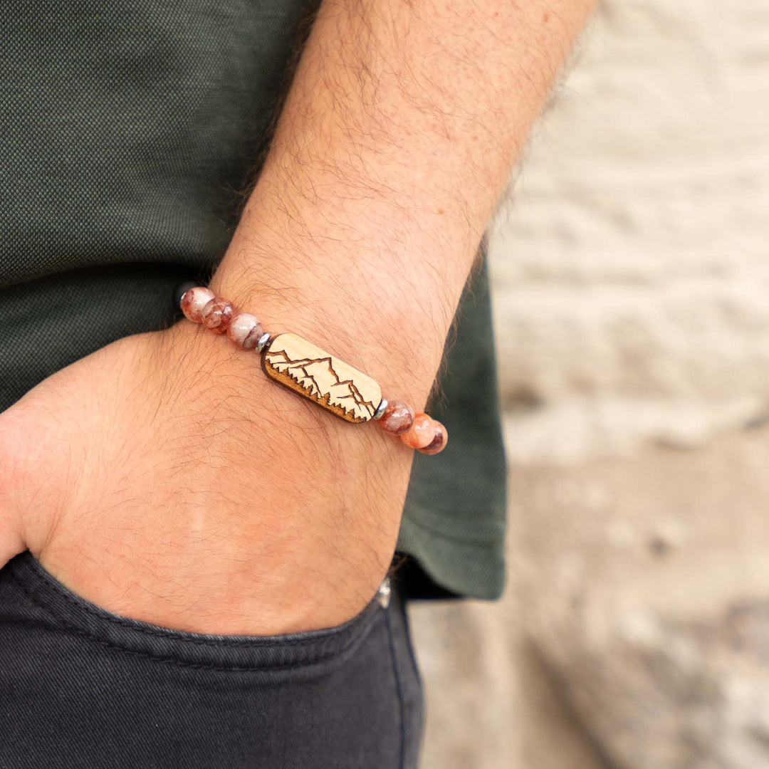 Graviertes Armband mit Bergsilhouette auf Kirschholz – roter Hematoid, schwarzer Onyx und individuell gravierbare Rückseite