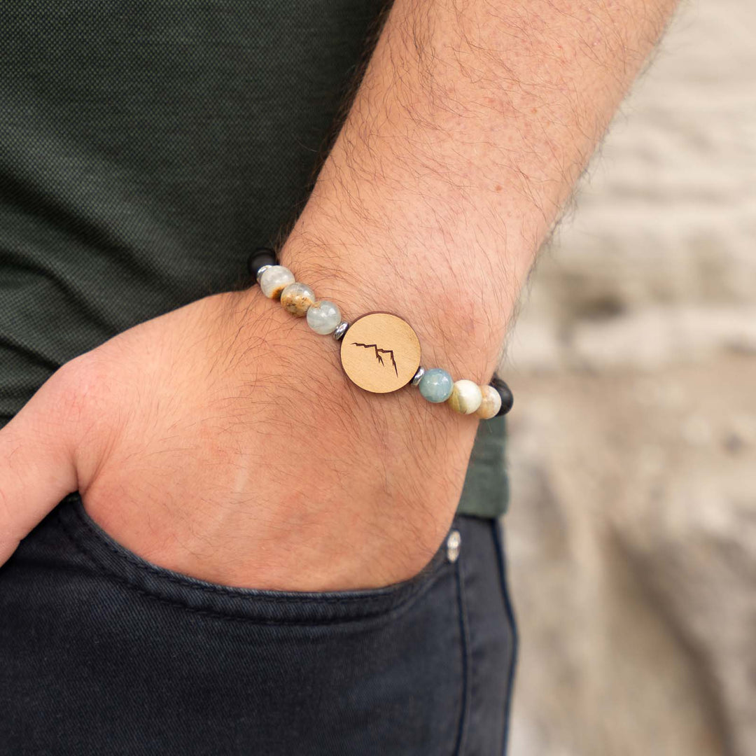 Edelsteinarmband mit Berggravur auf Kirschholz – kombiniert mit blauem Calcit und schwarzem Onyx für naturverbundenen Schmuck