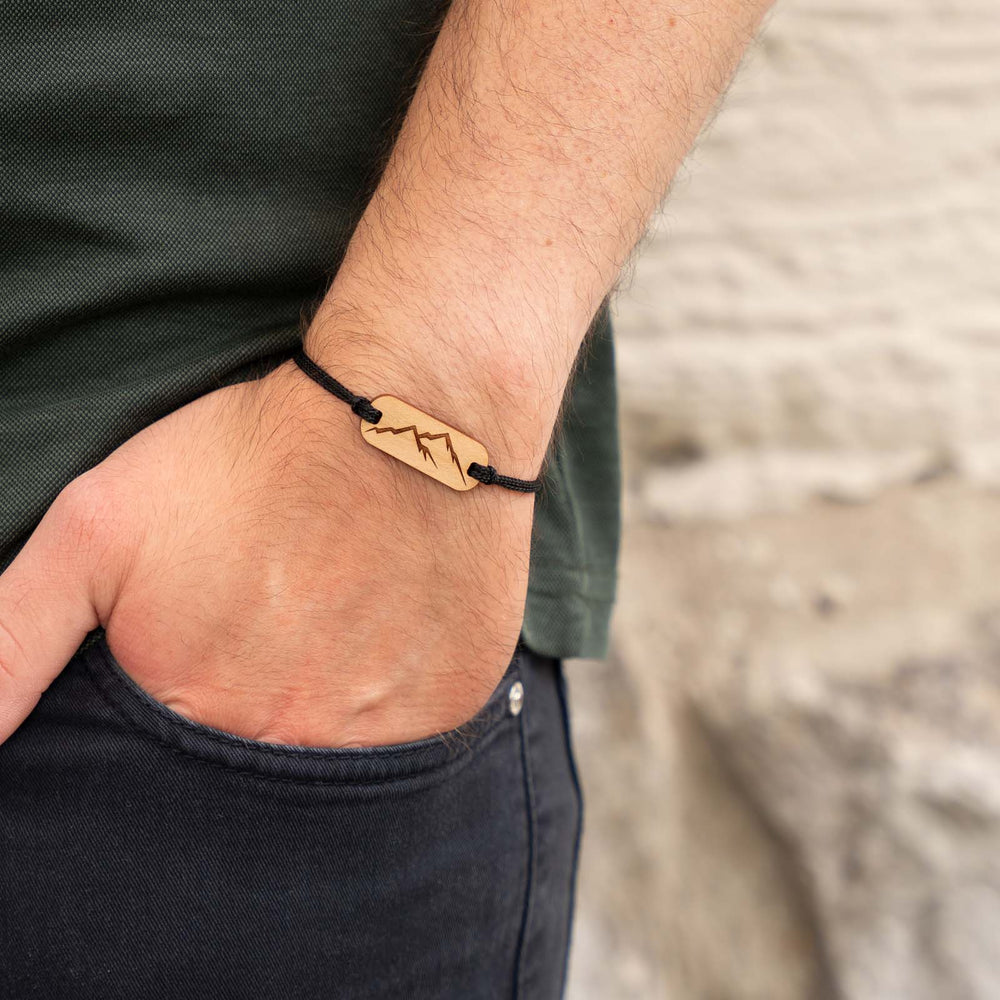 Armband mit Berggravur auf Kirschholz – naturverbundener Holzschmuck mit schwarzem Nylonband