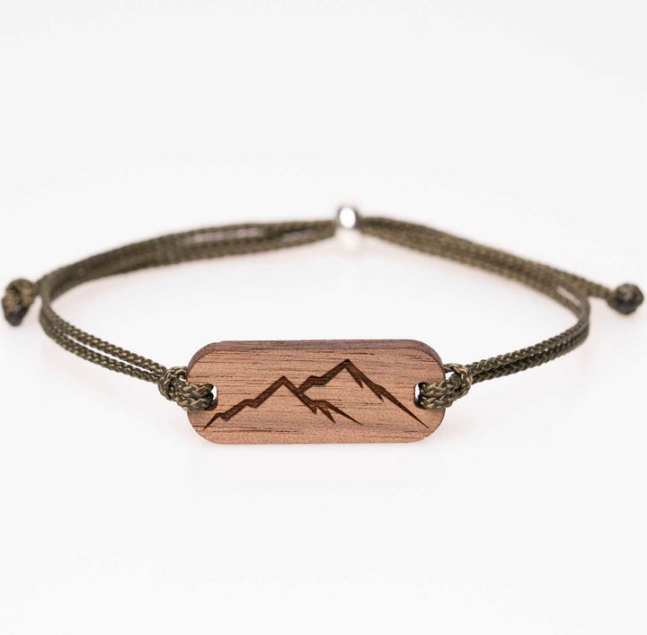 Handgemachtes Nussbaum Holzarmband mit klarer Berg Silhouette Gravur und olivgrünem Nylonband, personalisiert als Outdoor Geschenk für Alpenfans und Naturmenschen