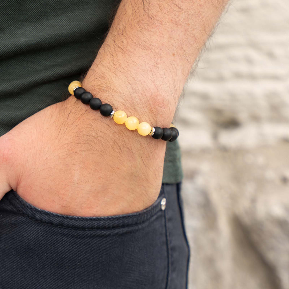 Tragebild eines Edelsteinarmbands mit gelbem Calcit und schwarzem Onyx – warmer, sonniger Naturstein-Schmuck am Handgelenk