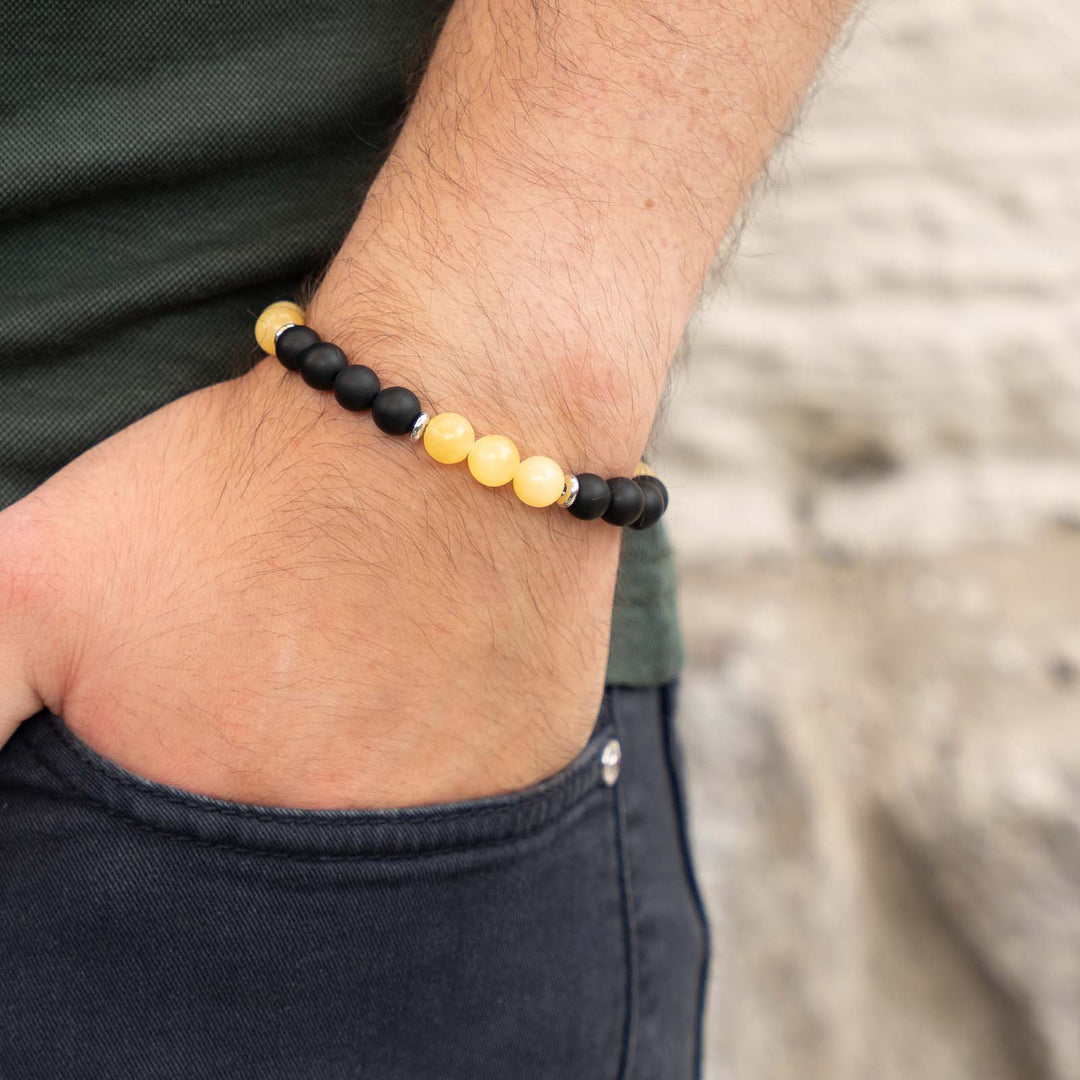 Tragebild eines Edelsteinarmbands mit gelbem Calcit und schwarzem Onyx – warmer, sonniger Naturstein-Schmuck am Handgelenk