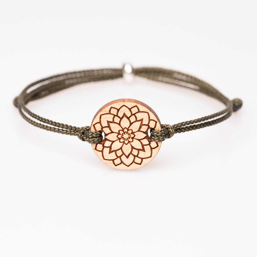 Kirschholz-Armband mit kunstvoll gravierter Mandala Blume, olivgrünes Nylonband, personalisierbarer Holzschmuck als spirituelle Geschenkidee, abgebildet auf weißem Hintergrund