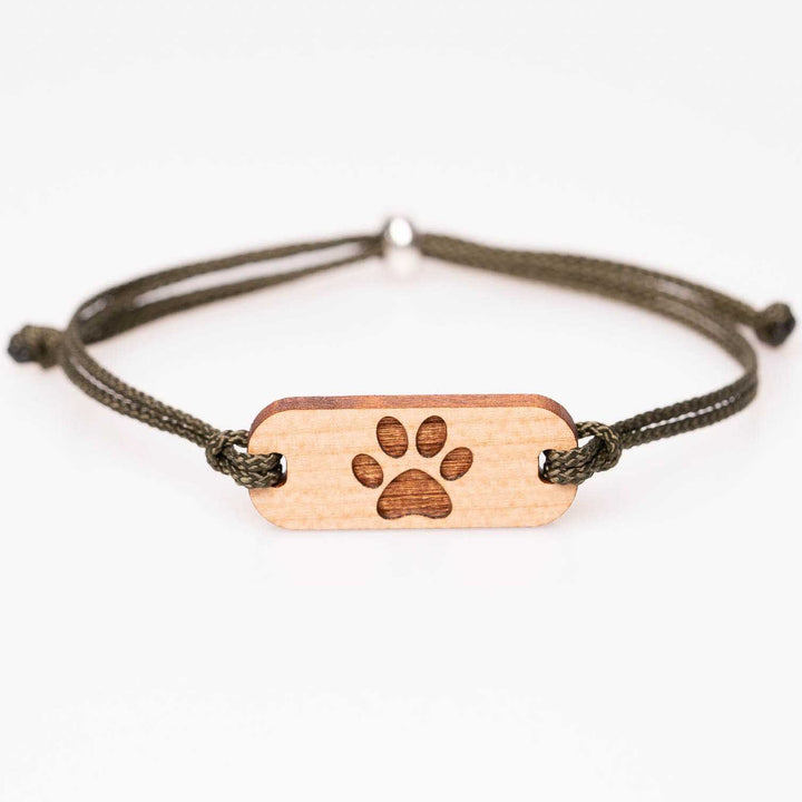 Naturbelassenes Armband aus Kirschholz mit eingravierter Pfote, kombiniert mit olivgrünem Nylonband, als personalisierbarer Holzschmuck – perfekte Geschenkidee für Tierfreunde