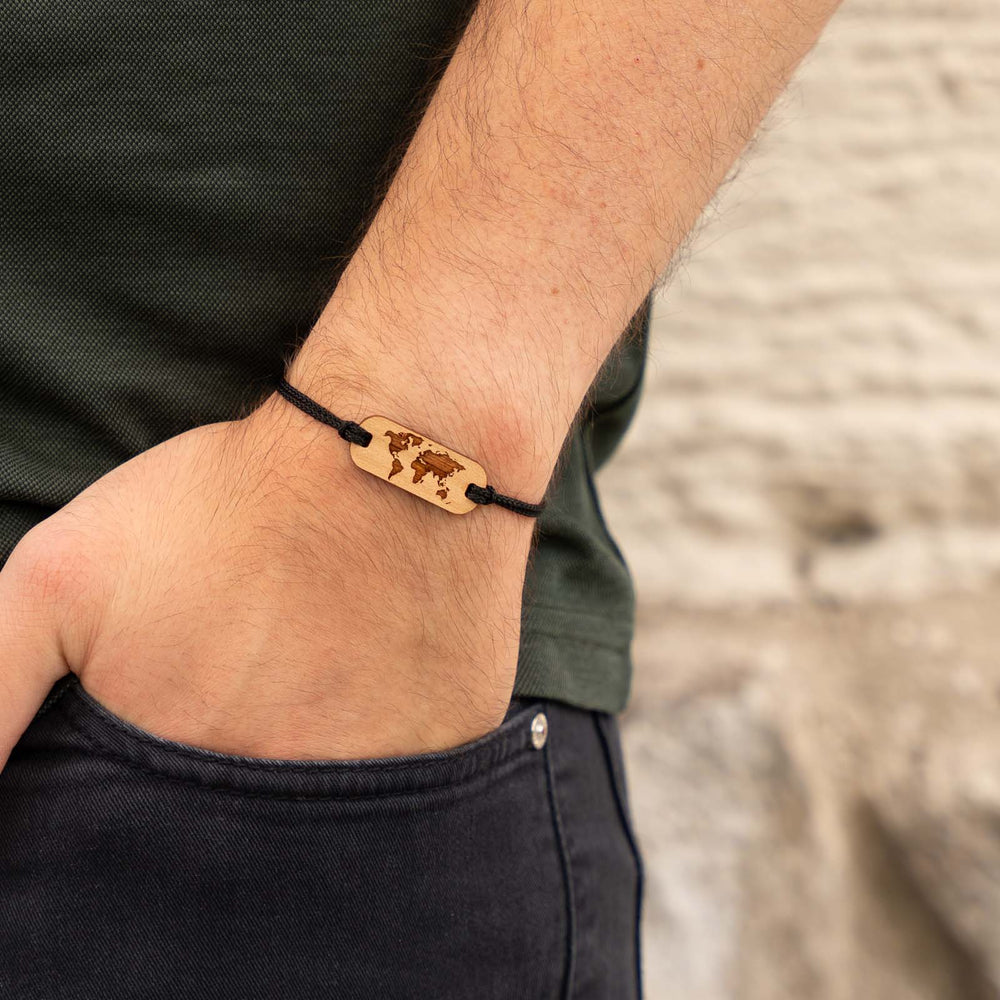 Armband mit gravierter Weltkarte auf Kirschholz – handgefertigter Holzschmuck mit schwarzem Nylonband