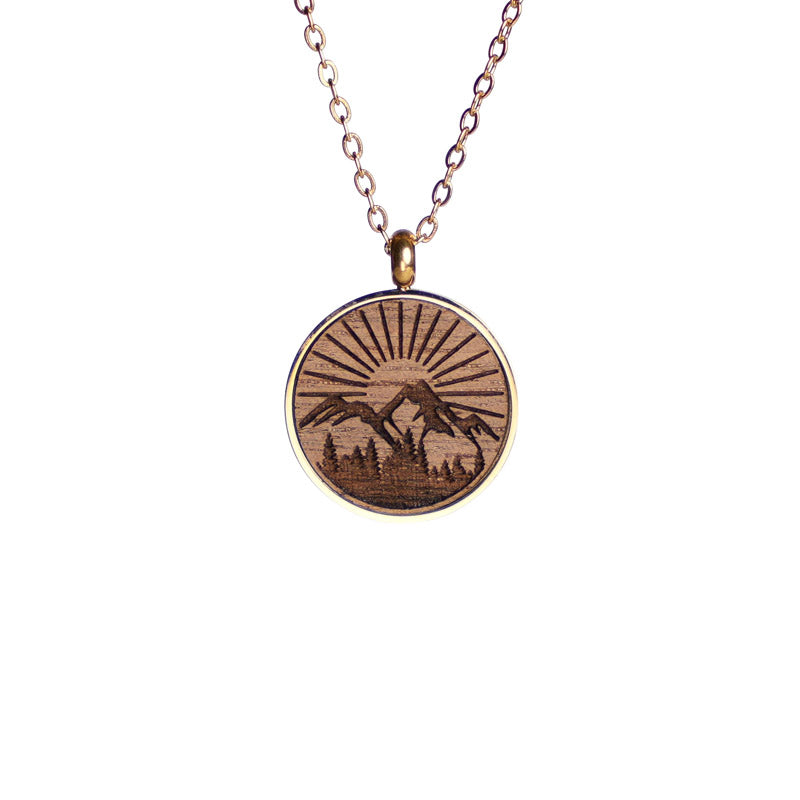 holzschmuck halskette in nussbaum mit vergoldeter fassung sowie halskette motiv berg natur