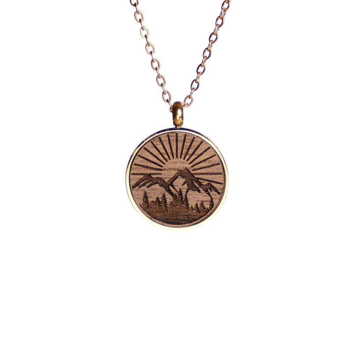 holzschmuck halskette in nussbaum mit vergoldeter fassung sowie halskette motiv berg natur